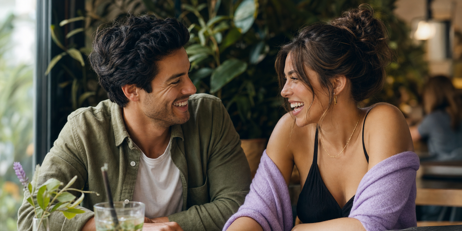 Two people laughing together at a cafe table